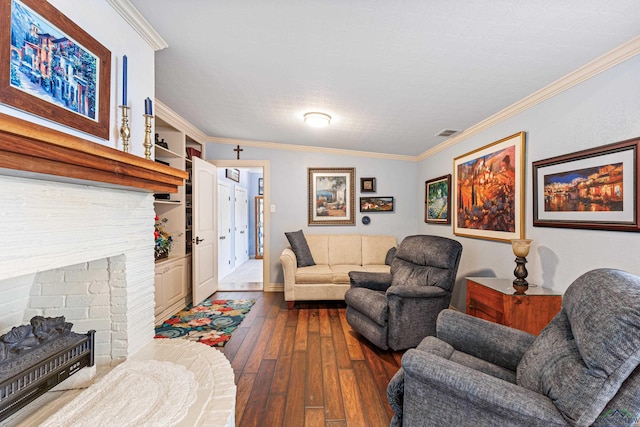 living room with hardwood / wood-style floors, built in features, ornamental molding, and a brick fireplace