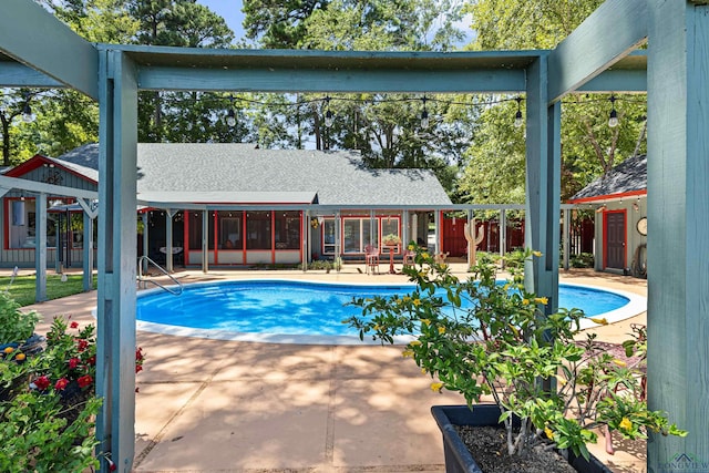 view of pool with a sunroom and a patio area