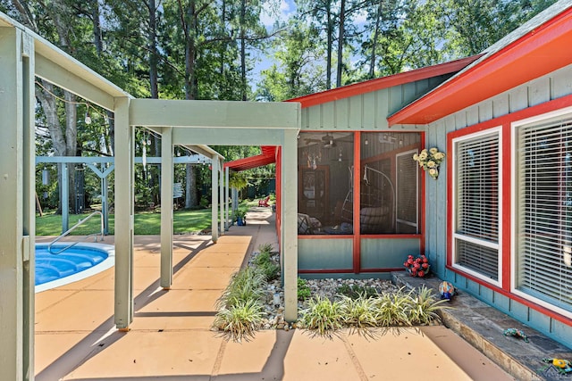 view of patio / terrace with a pool and a sunroom