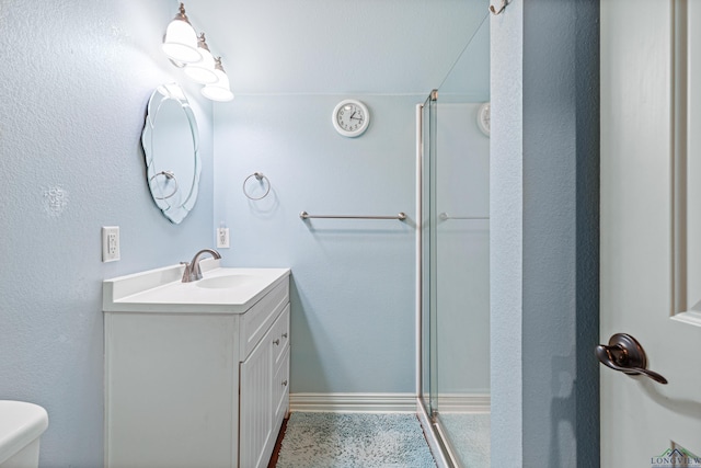 bathroom featuring vanity, toilet, and a shower with door