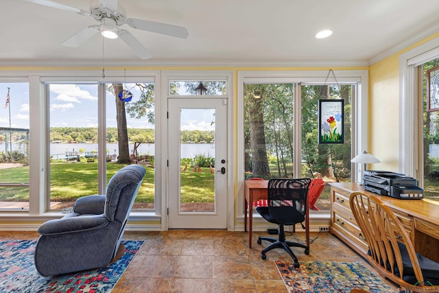 sunroom featuring ceiling fan and a water view