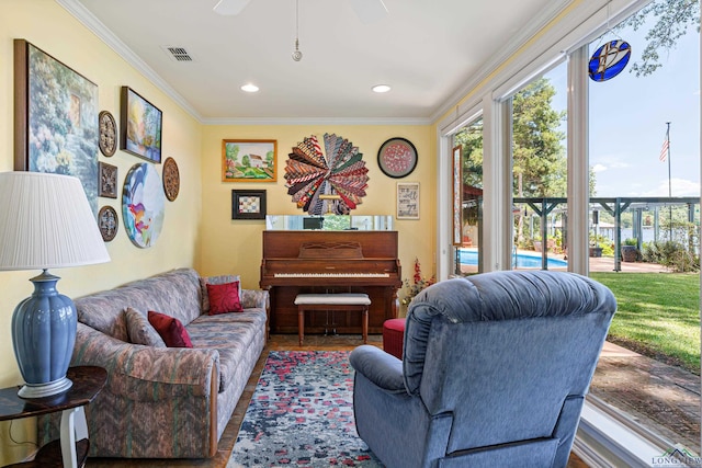 living room featuring tile patterned flooring, ceiling fan, and crown molding