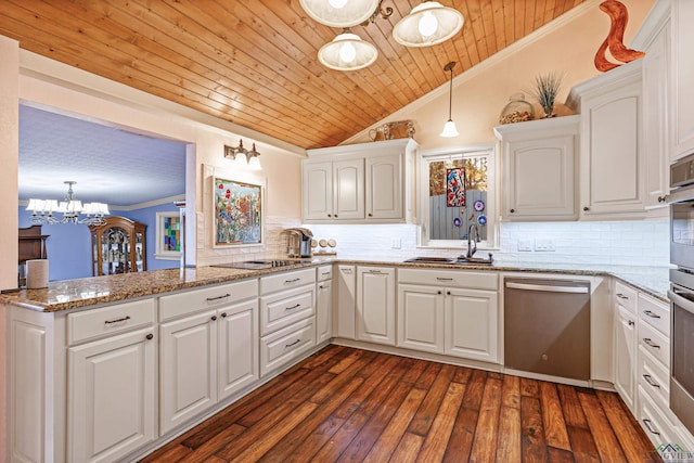 kitchen featuring kitchen peninsula, appliances with stainless steel finishes, backsplash, decorative light fixtures, and white cabinetry