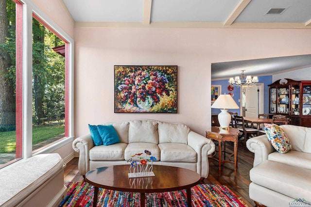 living room with plenty of natural light, a chandelier, and wood-type flooring