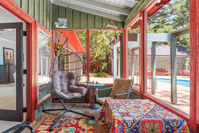 sunroom / solarium featuring vaulted ceiling with beams and a wealth of natural light