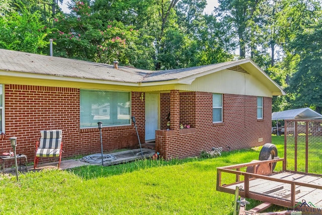 rear view of house featuring a yard and a carport