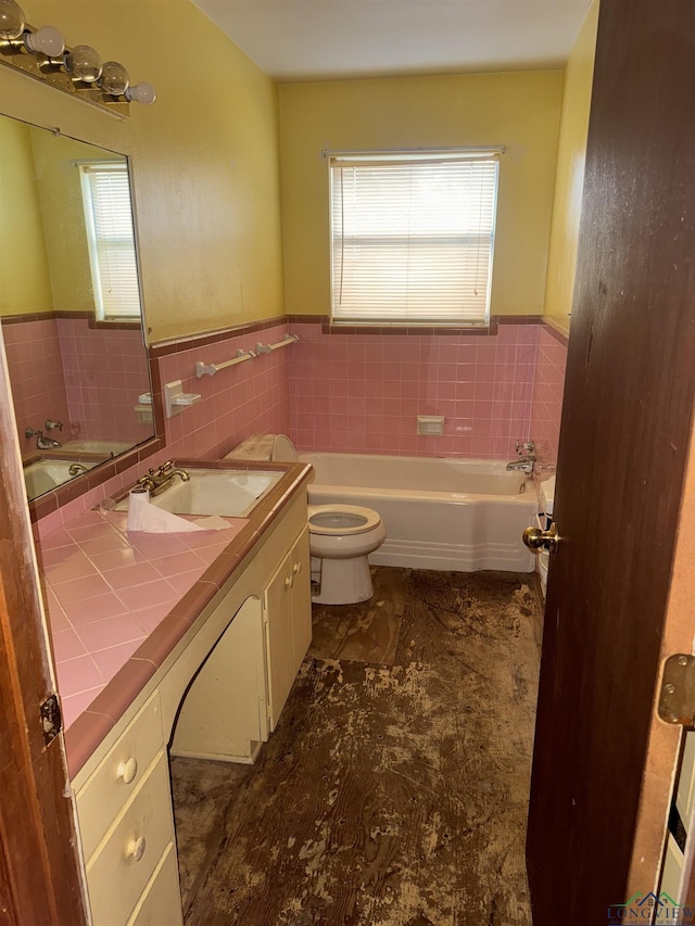 bathroom with a tub to relax in, vanity, and toilet