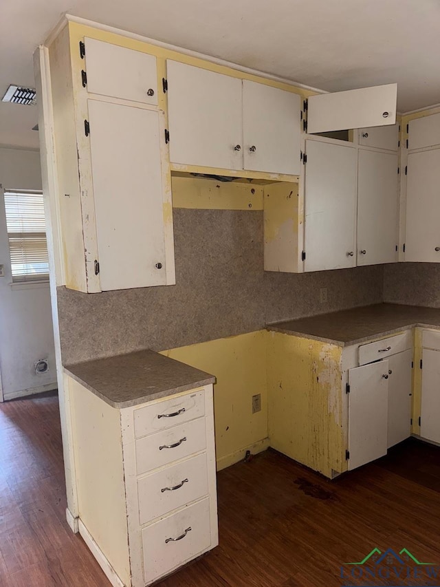 kitchen with dark wood-type flooring and white cabinetry