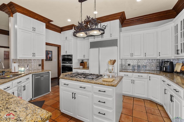 kitchen featuring hanging light fixtures, stainless steel appliances, a kitchen island, decorative backsplash, and white cabinets