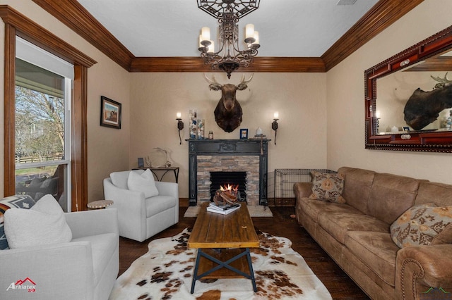 living room with crown molding, dark wood-type flooring, a fireplace, and a chandelier