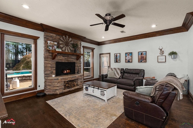 living room with a textured ceiling, ceiling fan, a fireplace, and dark wood-type flooring