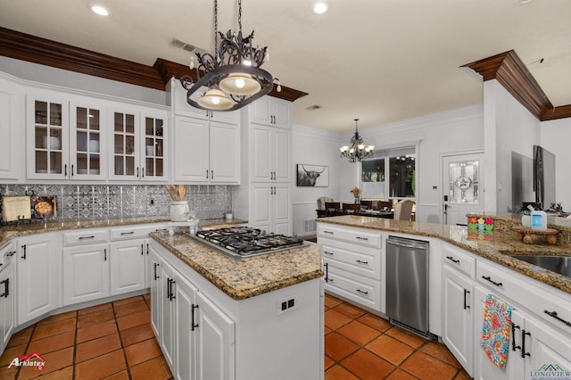 kitchen with stainless steel appliances, a kitchen island, decorative light fixtures, a notable chandelier, and white cabinetry