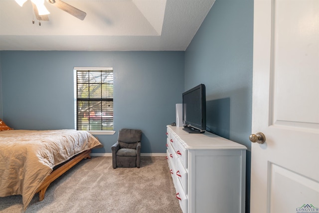 carpeted bedroom with a raised ceiling and ceiling fan