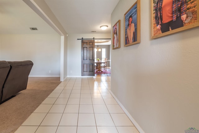 hallway with carpet and a barn door