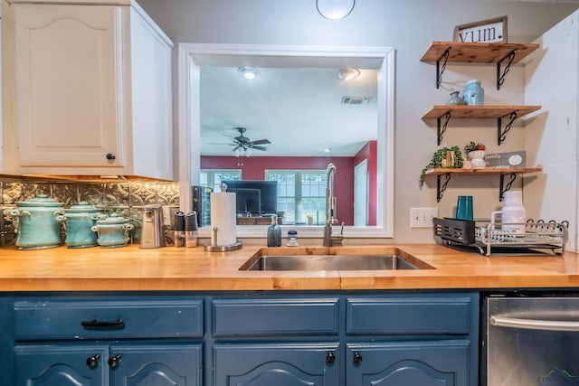 kitchen with ceiling fan, sink, blue cabinets, backsplash, and white cabinets