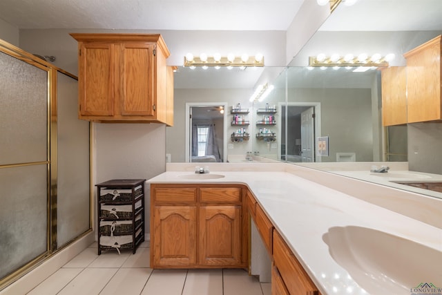 bathroom featuring tile patterned floors, vanity, and a shower with shower door