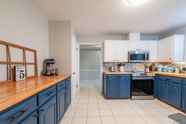 kitchen featuring white cabinets, stainless steel appliances, and wood counters