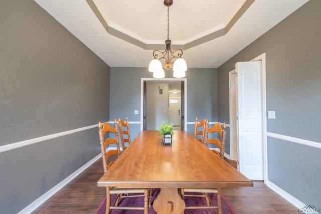 dining room with a tray ceiling, an inviting chandelier, dark hardwood / wood-style floors, and crown molding