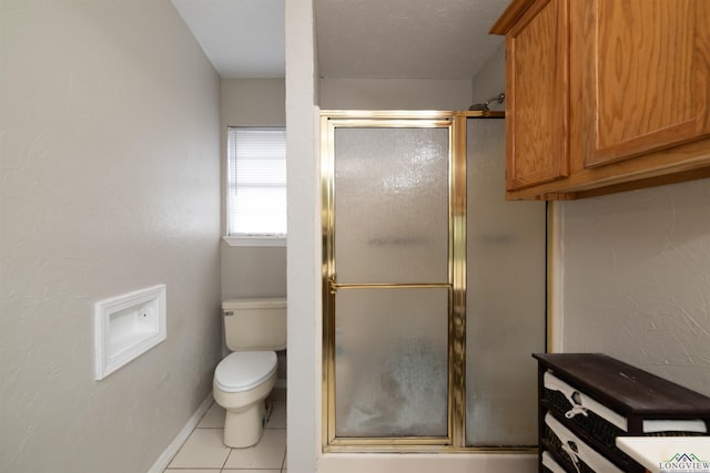 bathroom featuring tile patterned flooring, an enclosed shower, and toilet