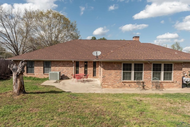 rear view of property featuring a patio, cooling unit, and a lawn