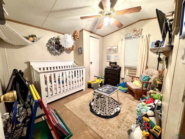 carpeted bedroom featuring a textured ceiling, vaulted ceiling, ceiling fan, crown molding, and a crib