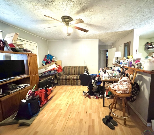 interior space with ceiling fan, a textured ceiling, and hardwood / wood-style flooring