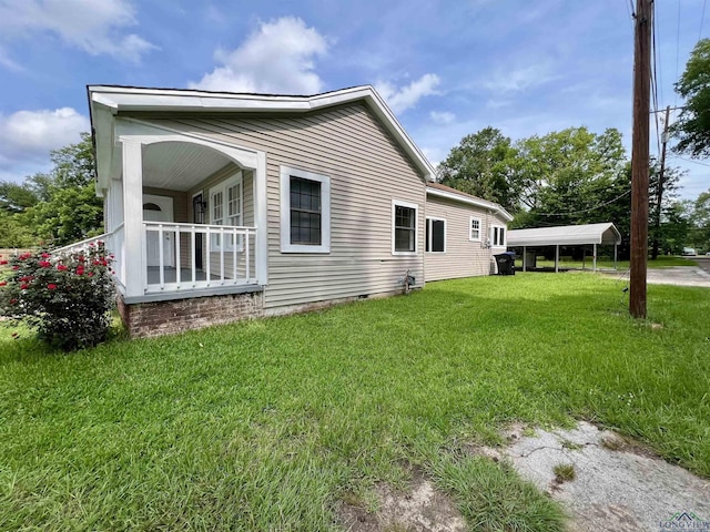 1411 E Timpson St, Longview, TX 75601 - view of side of home with a lawn, a detached carport, and crawl space