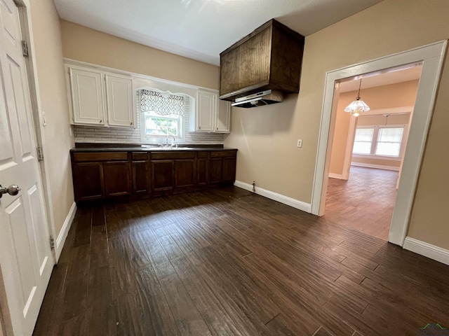 1411 E Timpson St, Longview, TX 75601 - kitchen featuring dark countertops, dark wood-style floors, plenty of natural light, and white cabinetry