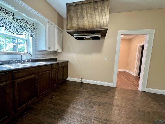 1411 E Timpson St, Longview, TX 75601 - kitchen with a sink, dark countertops, dark wood finished floors, extractor fan, and tasteful backsplash