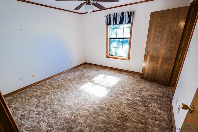 empty room featuring ceiling fan and crown molding