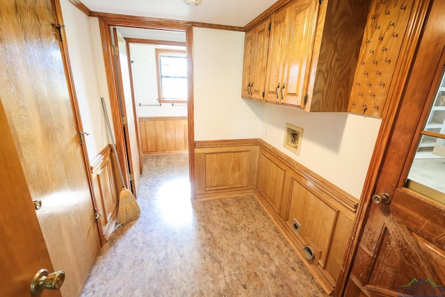 laundry area featuring cabinets, washer hookup, crown molding, and wood walls