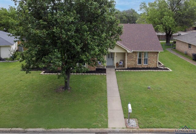 144 Hollie Cir, Sulphur Springs, TX 75482 - view of front of home with brick siding, a porch, a front lawn, and roof with shingles