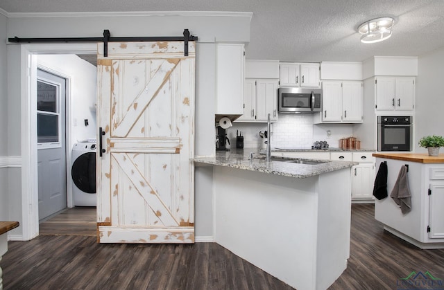 144 Hollie Cir, Sulphur Springs, TX 75482 - kitchen with oven, washer / clothes dryer, stainless steel microwave, white cabinetry, and dark wood finished floors