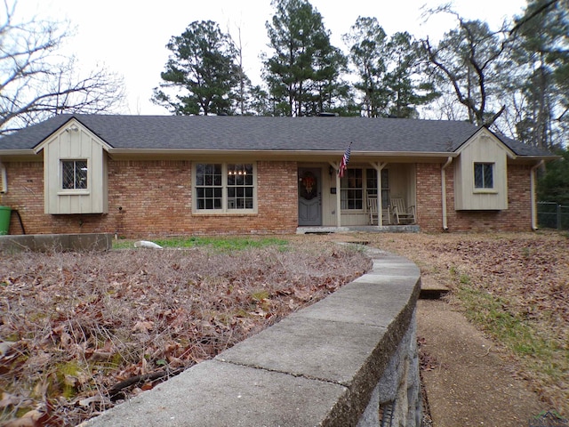 single story home featuring board and batten siding, brick siding, and roof with shingles