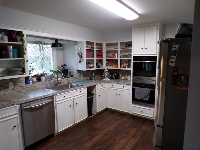 kitchen featuring dark wood finished floors, open shelves, a sink, appliances with stainless steel finishes, and white cabinetry