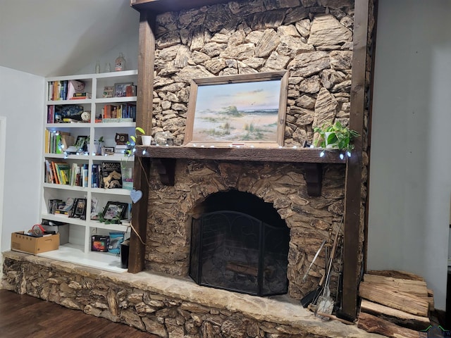 interior space with a fireplace, lofted ceiling, and wood finished floors