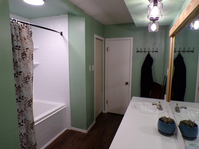 bathroom with double vanity, shower / bathtub combination with curtain, wood finished floors, and a sink