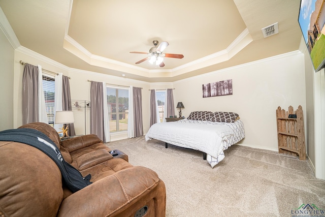 bedroom with crown molding, carpet flooring, a tray ceiling, and ceiling fan