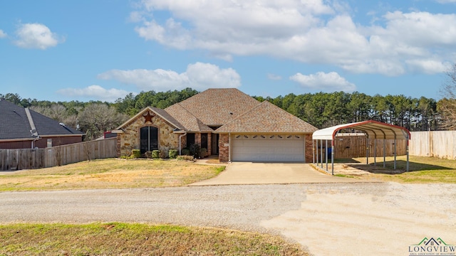 ranch-style home featuring a carport, a garage, and a front yard