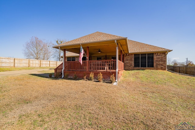 view of front of home featuring a wooden deck, ceiling fan, and a front lawn