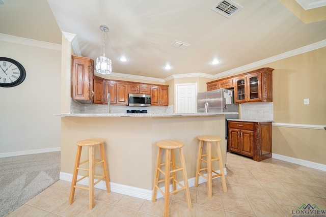 kitchen with light tile patterned flooring, stainless steel appliances, and a kitchen bar