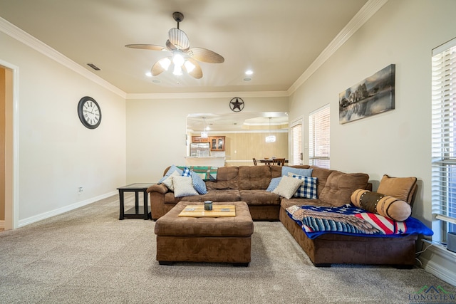 carpeted living room with ornamental molding and ceiling fan