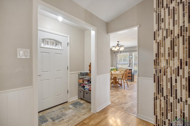 entryway with a notable chandelier and vaulted ceiling