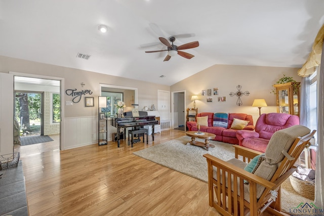 living room featuring ceiling fan, light hardwood / wood-style floors, and lofted ceiling