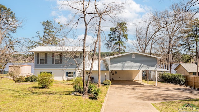 view of front of home with a front yard, an attached carport, driveway, and fence