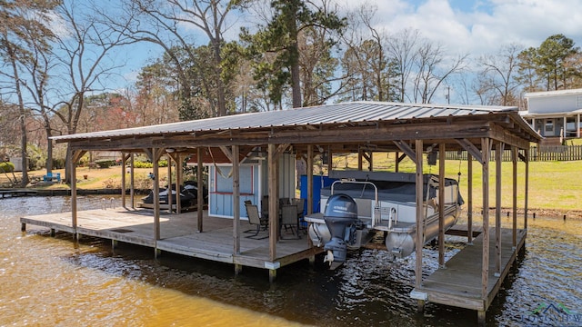 view of dock with a water view, boat lift, and a lawn