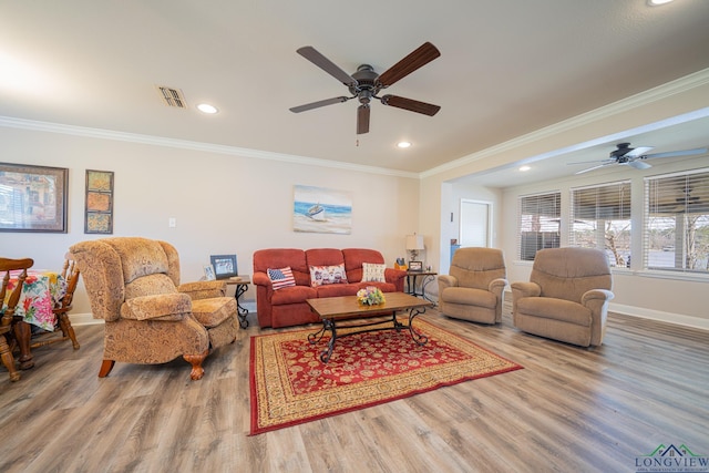 living area featuring visible vents, a ceiling fan, and wood finished floors