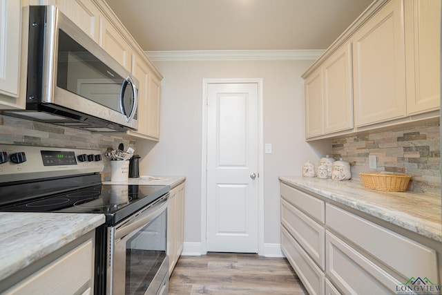 kitchen with light wood-style flooring, tasteful backsplash, appliances with stainless steel finishes, crown molding, and baseboards