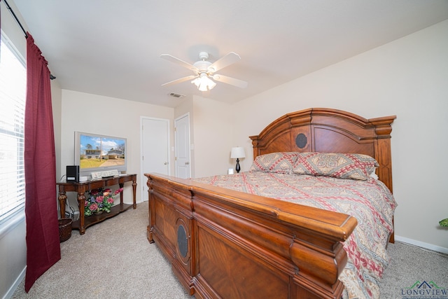 bedroom featuring visible vents, light colored carpet, baseboards, and a ceiling fan