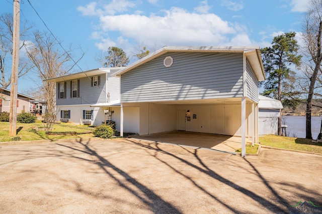 view of front of home with a front lawn, a carport, and driveway